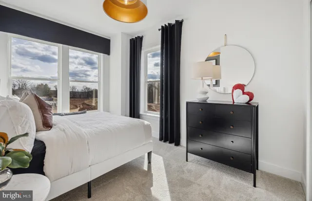 a bedroom with a bed and dresser with mirror