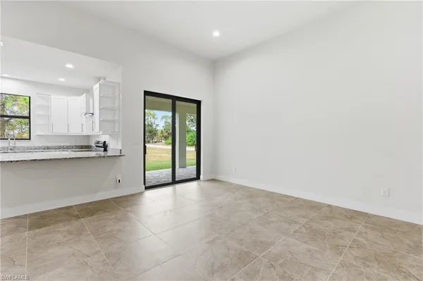 a view of an empty room with window and cabinet
