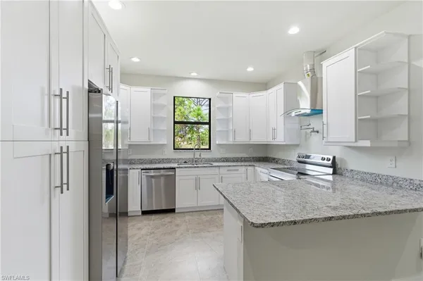 a kitchen with stainless steel appliances granite countertop a sink and a granite counter tops