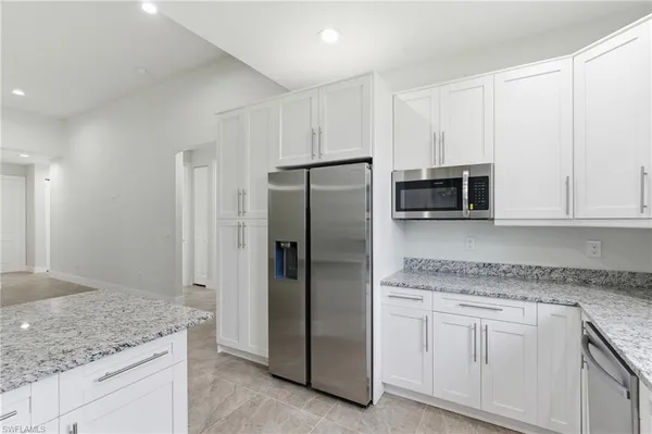 a kitchen with granite countertop cabinets and refrigerator