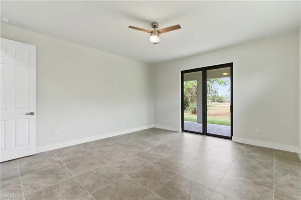 an empty room with fan and windows