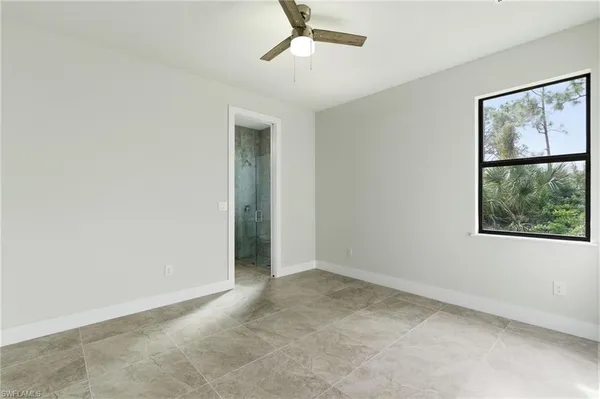 an empty room with a ceiling fan and a window
