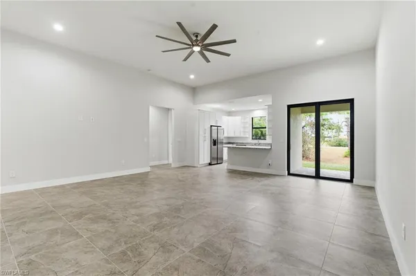 an empty room with chandelier and a ceiling fan