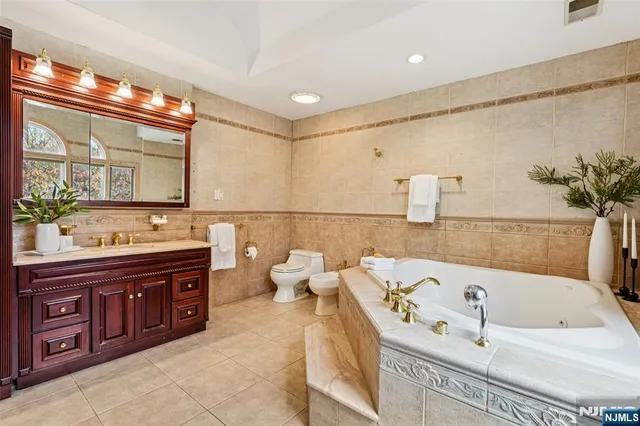 a bathroom with a tub sink and mirror