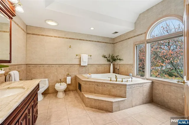 a bathroom with a sink a toilet and a mirror