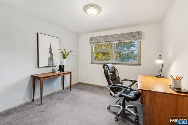 a view of a workspace with furniture and a window