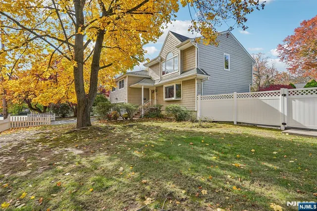 a view of a yard in front of a house with large tree