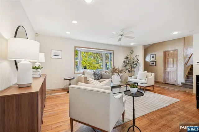 a living room with furniture a window and wooden floor