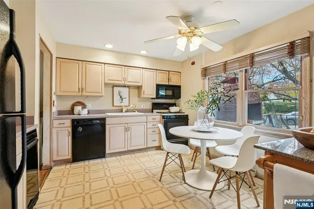 a kitchen with stainless steel appliances kitchen island granite countertop a refrigerator a stove a sink dishwasher a dining table and chairs with wooden floor