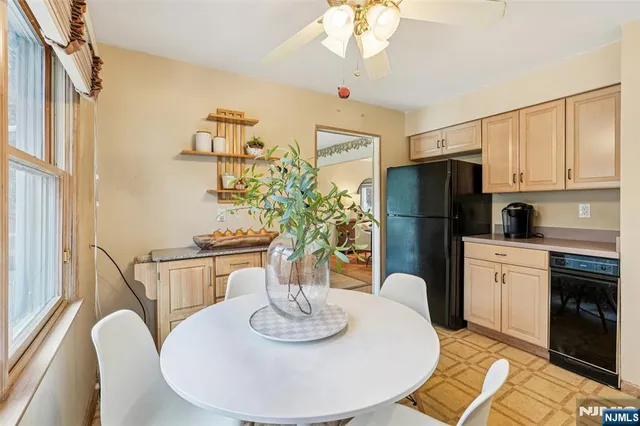 a kitchen with stainless steel appliances granite countertop a dining table and chairs