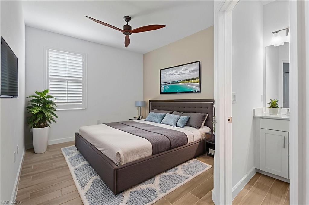 1779 Hagen Court Naples, FL 34120 - Photo 12 of 36 a bedroom with a large bed and a chandelier