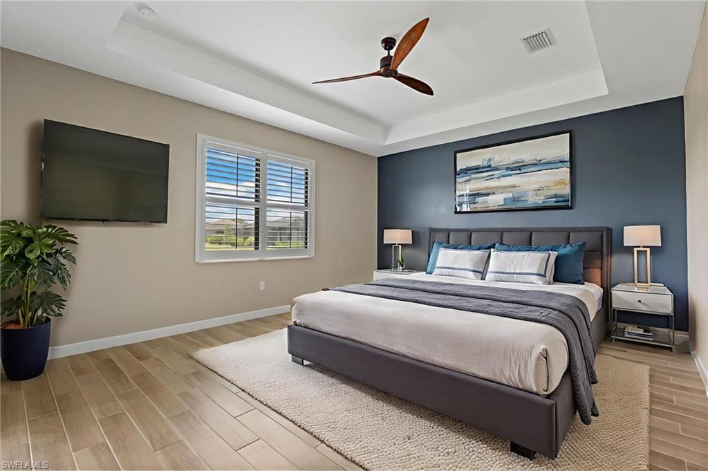 1779 Hagen Court Naples, FL 34120 - Photo 20 of 36 a spacious bedroom with a bed and a flat screen tv