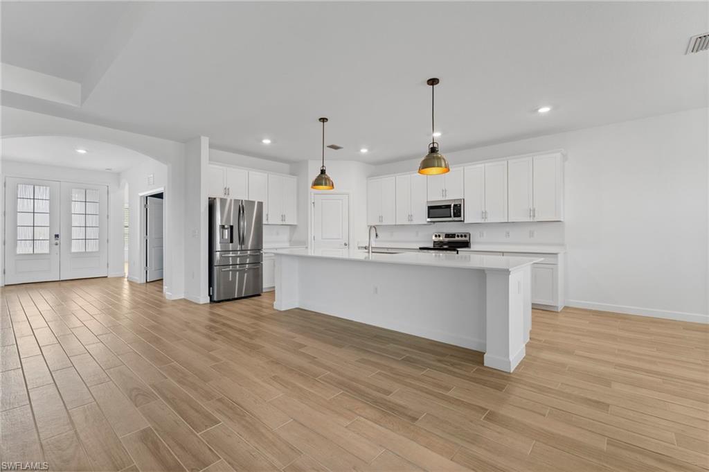 1779 Hagen Court Naples, FL 34120 - Photo 2 of 36 a kitchen with stainless steel appliances granite countertop a sink a stove a refrigerator and island with wooden floor
