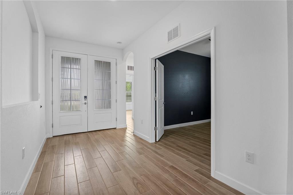 1779 Hagen Court Naples, FL 34120 - Photo 24 of 36 an empty room with wooden floor and entrance