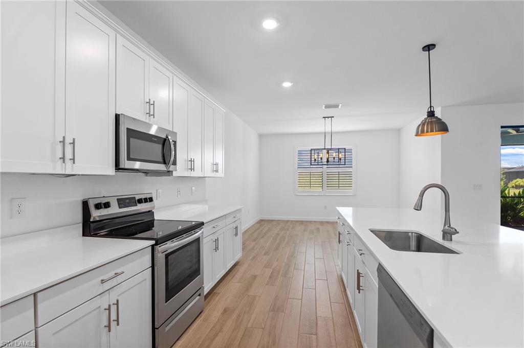 1779 Hagen Court Naples, FL 34120 - Photo 7 of 36 a kitchen with stainless steel appliances a sink a stove top oven a counter space and cabinets