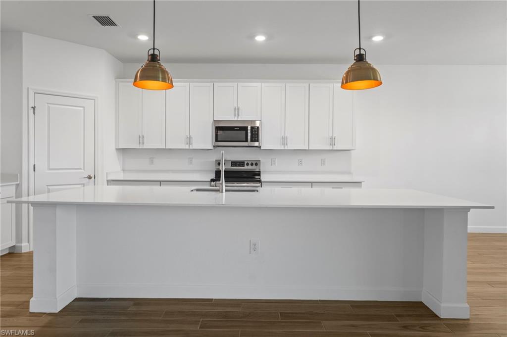 1779 Hagen Court Naples, FL 34120 - Photo 8 of 36 a kitchen with stainless steel appliances a stove a sink and a microwave