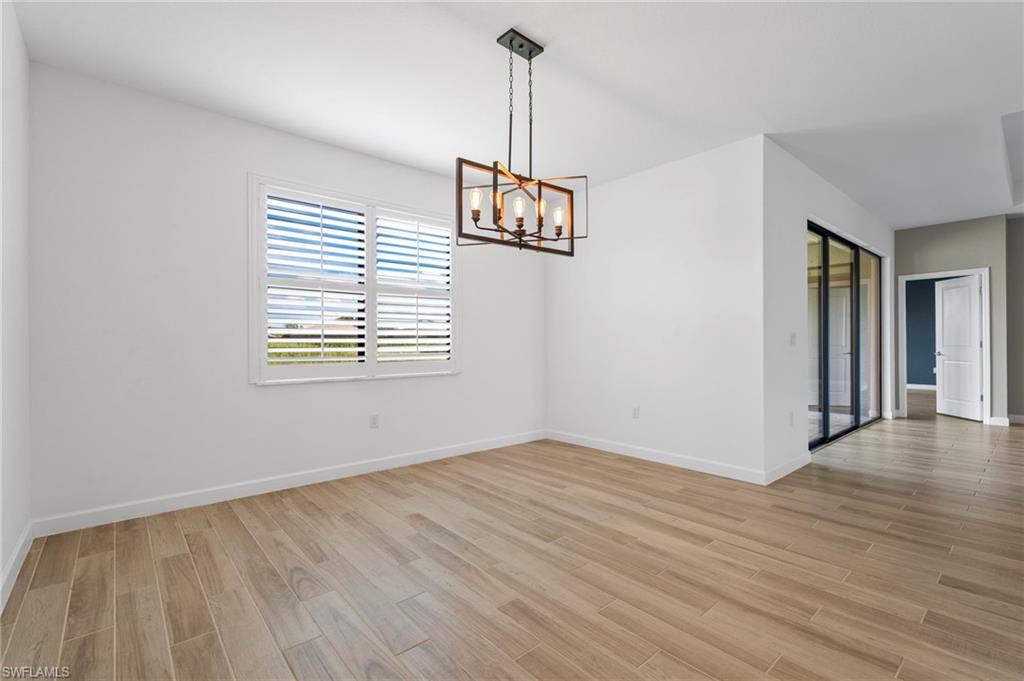 1779 Hagen Court Naples, FL 34120 - Photo 9 of 36 an empty room with wooden floor and windows