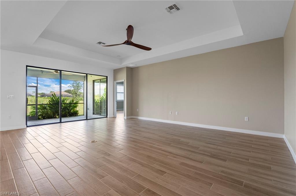 1779 Hagen Court Naples, FL 34120 - Photo 10 of 36 a view of empty room with wooden floor and fan