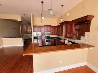 a kitchen with stainless steel appliances granite countertop a sink a stove and a wooden floors