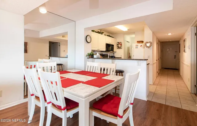 a kitchen with a dining table chairs and refrigerator