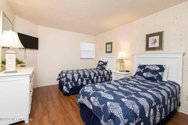 a bedroom with two beds and painting on the wall