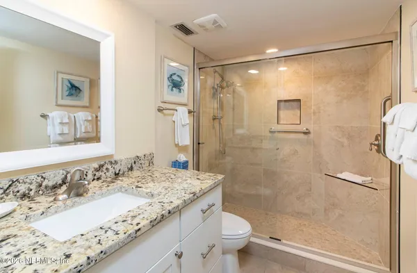 a bathroom with a granite countertop sink toilet and shower