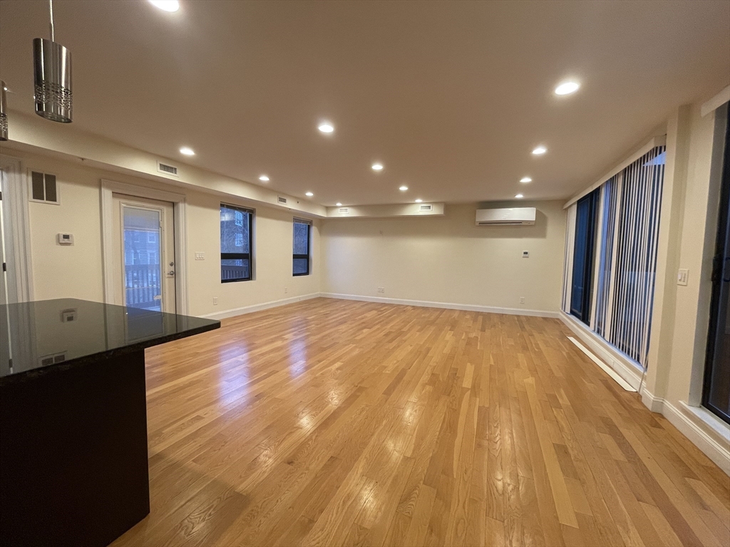 a view of an empty room with wooden floor
