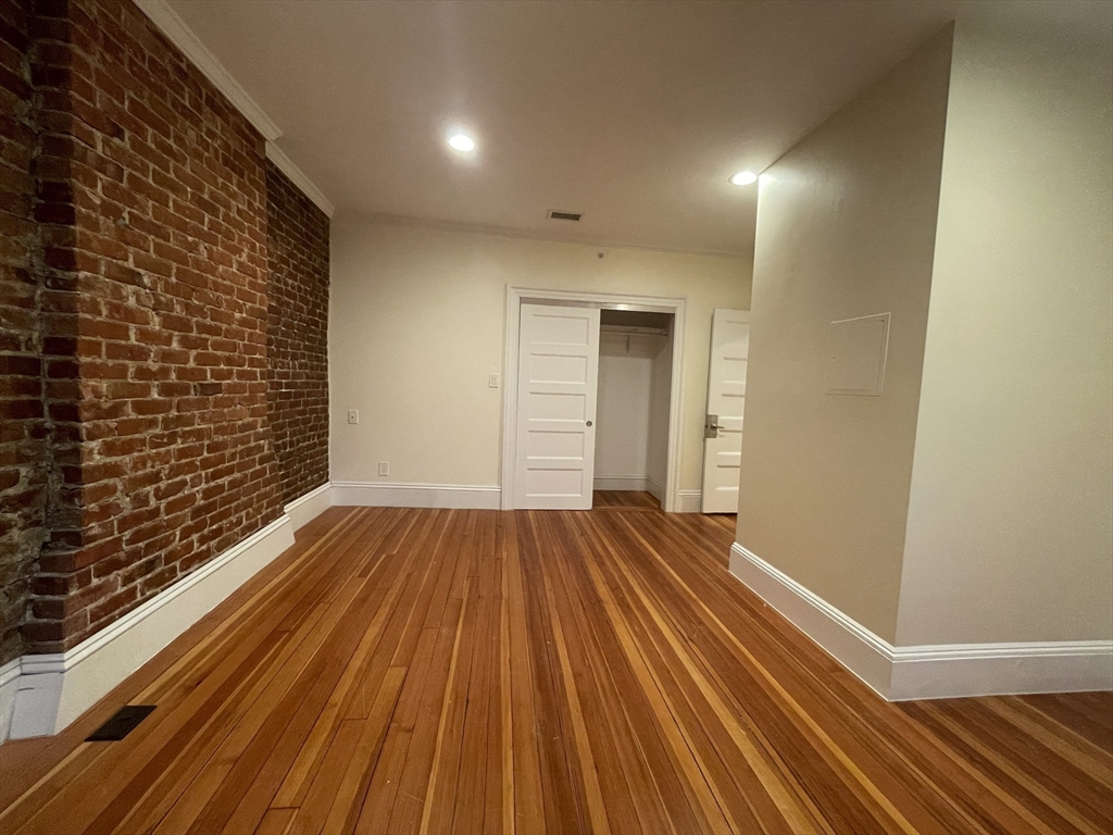 1616 Beacon Street, Unit 3 Brookline, MA 02446 - Photo 14 of 17 a view of a room with wooden floor and brick walls