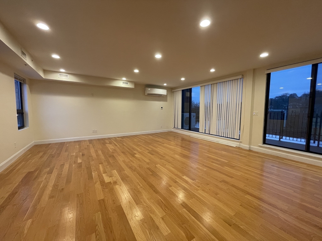 1616 Beacon Street, Unit 3 Brookline, MA 02446 - Photo 3 of 17 a view of an empty room with wooden floor and closet