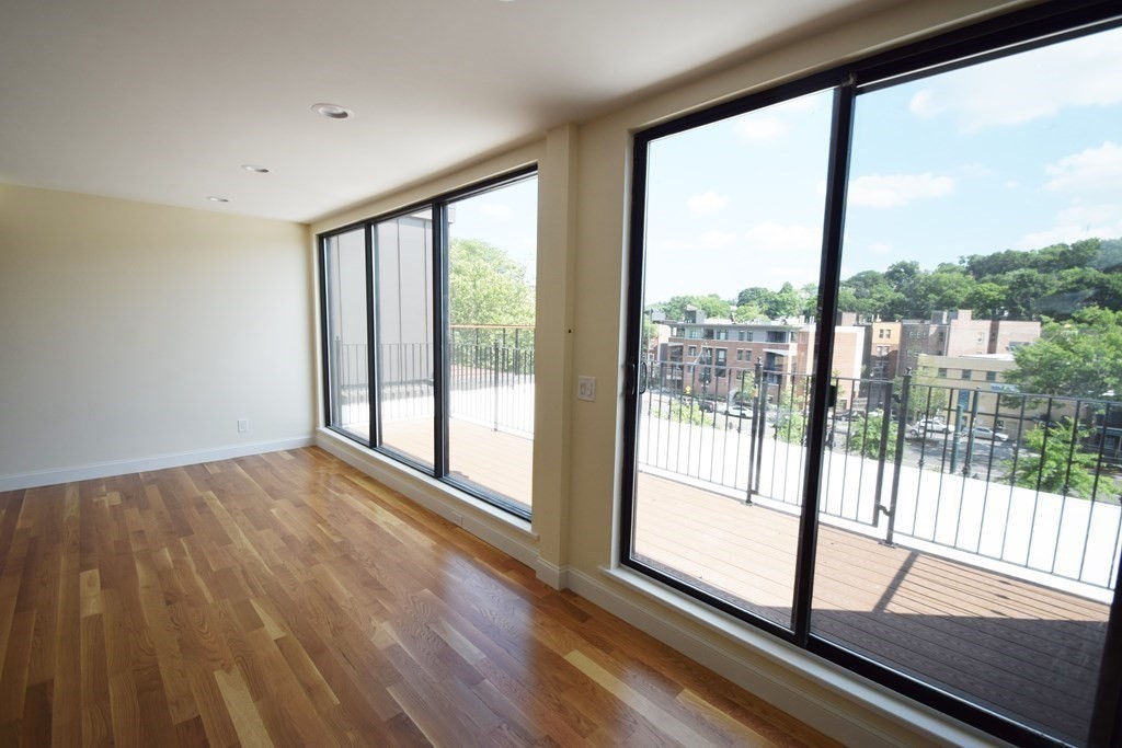 1616 Beacon Street, Unit 3 Brookline, MA 02446 - Photo 5 of 17 a view of an empty room with wooden floor and a window