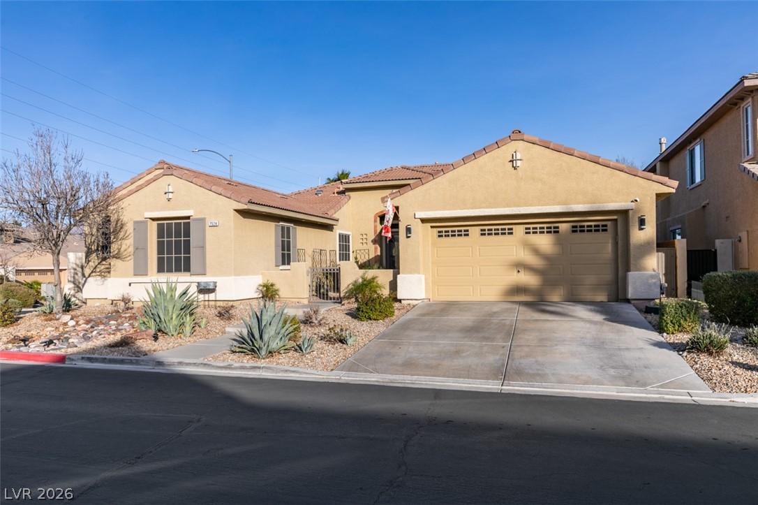 7524 Midnight Rambler Street Las Vegas, NV 89149 - Photo 2 of 51 A desert-friendly landscape surrounds this warm stucco residence, featuring a two-car garage and inviting entry.