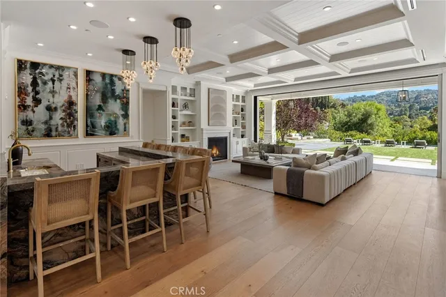 a living room with furniture a fireplace and floor to ceiling windows