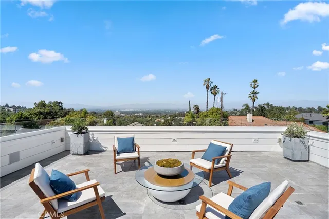 a view of a terrace with furniture and a garden