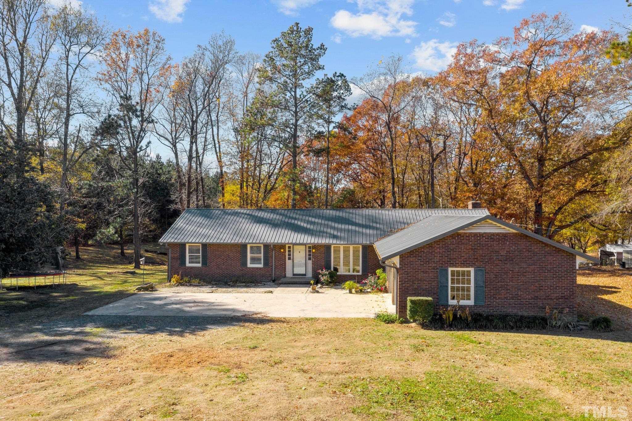 1275 Spring Valley Lake Road Henderson, NC 27537 - Photo 29 of 30 a front view of a house with a yard covered with trees