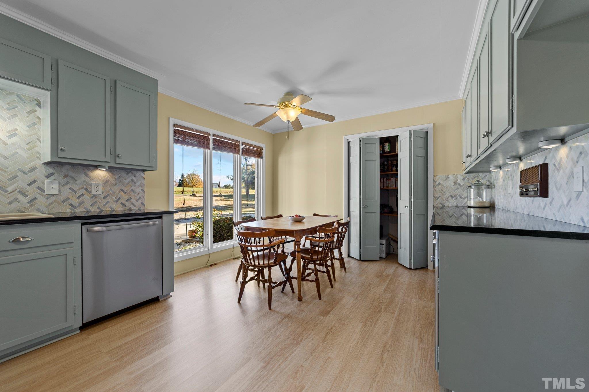 1275 Spring Valley Lake Road Henderson, NC 27537 - Photo 8 of 30 a kitchen with stainless steel appliances granite countertop a stove top oven a sink dishwasher a dining table and chairs with wooden floor