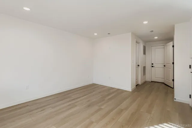 a kitchen with refrigerator a sink and wooden floor