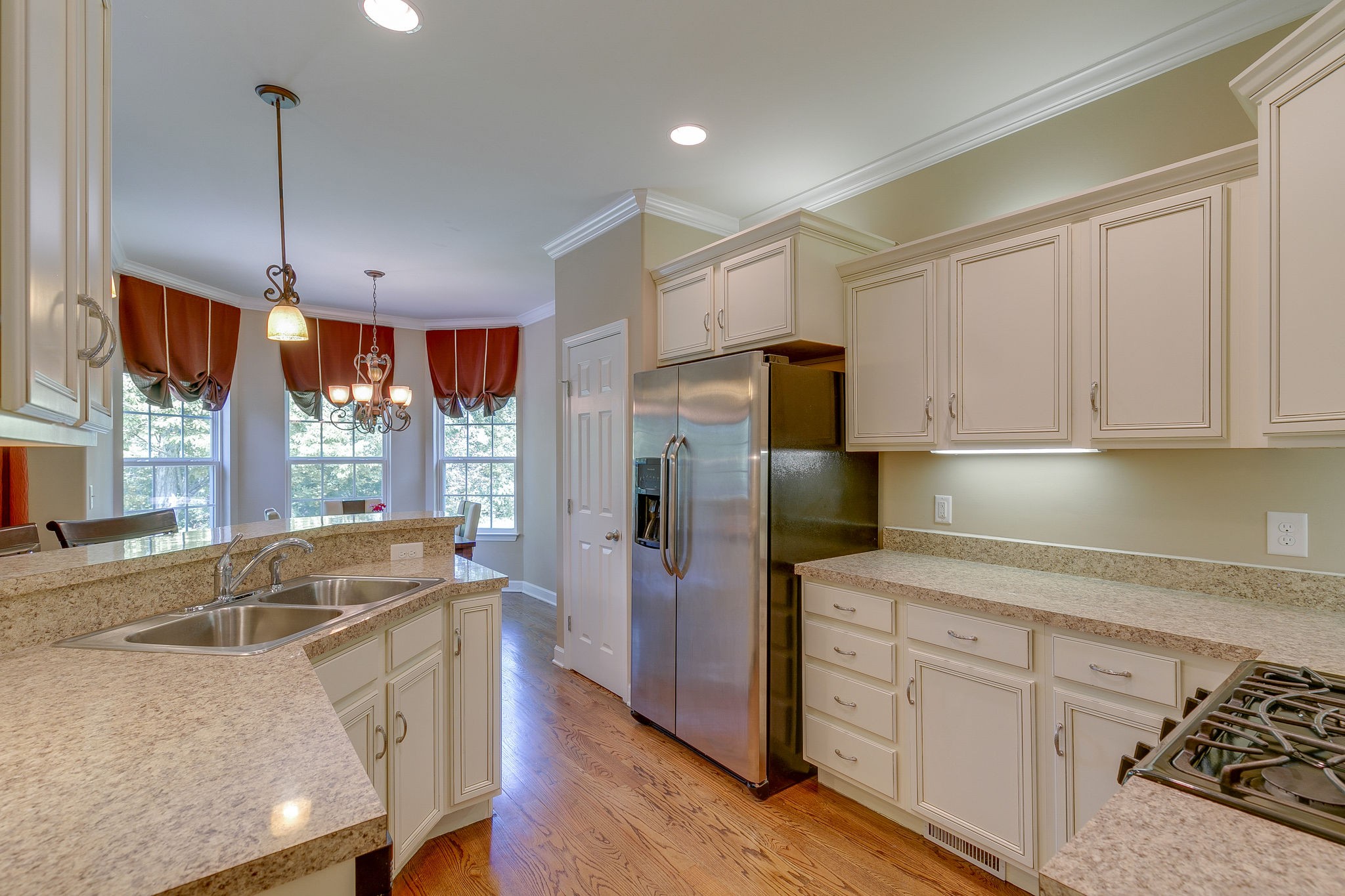 1104 Golf View Way Spring Hill, TN 37174 - Photo 9 of 31 a kitchen with stainless steel appliances granite countertop a refrigerator a sink dishwasher a stove and white cabinets with wooden floor