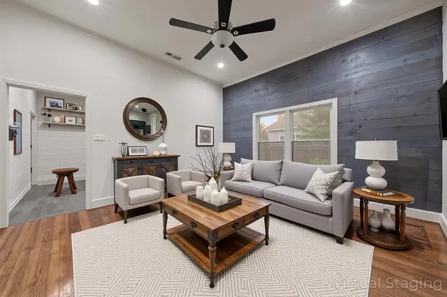 a living room with furniture a clock on wall and a large window
