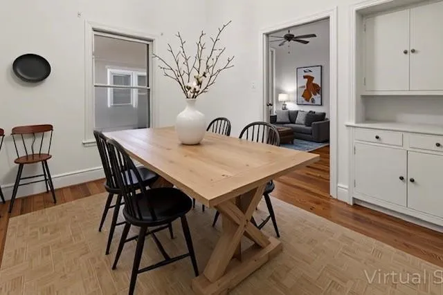 a view of a dining room and livingroom with furniture wooden floor and a rug