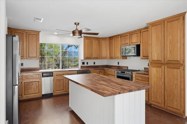 a kitchen with stainless steel appliances granite countertop a stove a sink dishwasher and a refrigerator