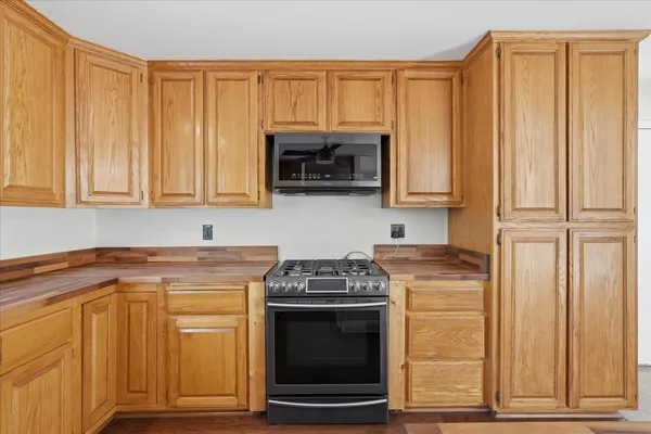 a kitchen with granite countertop white cabinets and stainless steel appliances