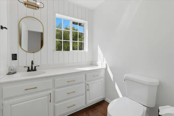 a bathroom with a toilet sink and mirror