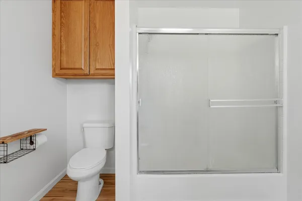 a white toilet sitting next to a shower