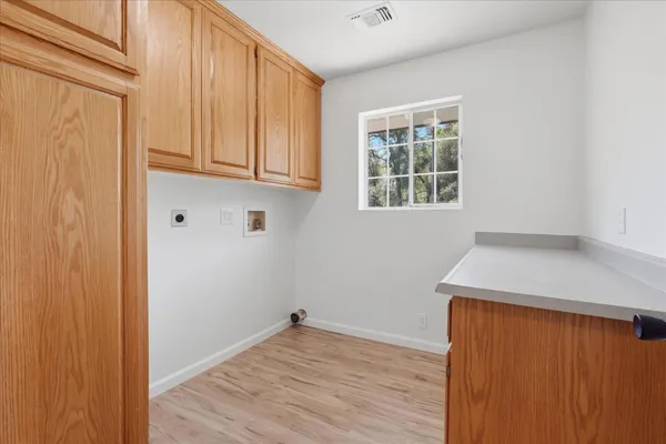 a view of a kitchen with wooden floor and a window