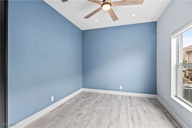 an empty room with a window and wooden floor