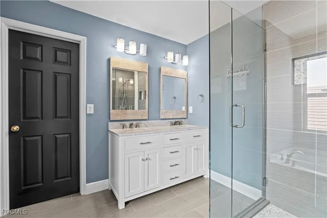 view of a bathroom with a shower a sink and a mirror