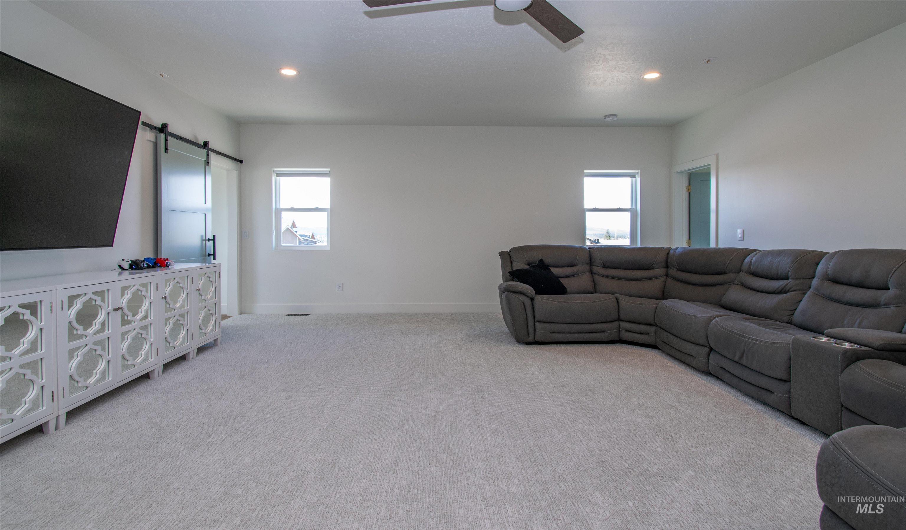 44 Big Moose Road McCall, ID 83638 - Photo 31 of 50 Spacious carpeted room featuring recessed lighting, a ceiling fan, and two windows providing natural illumination