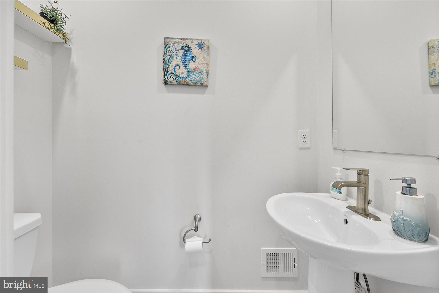 9503 Seascape Lane, Unit 4 Berlin, MD 21811 - Photo 26 of 52 a bathroom with a sink mirror and toilet