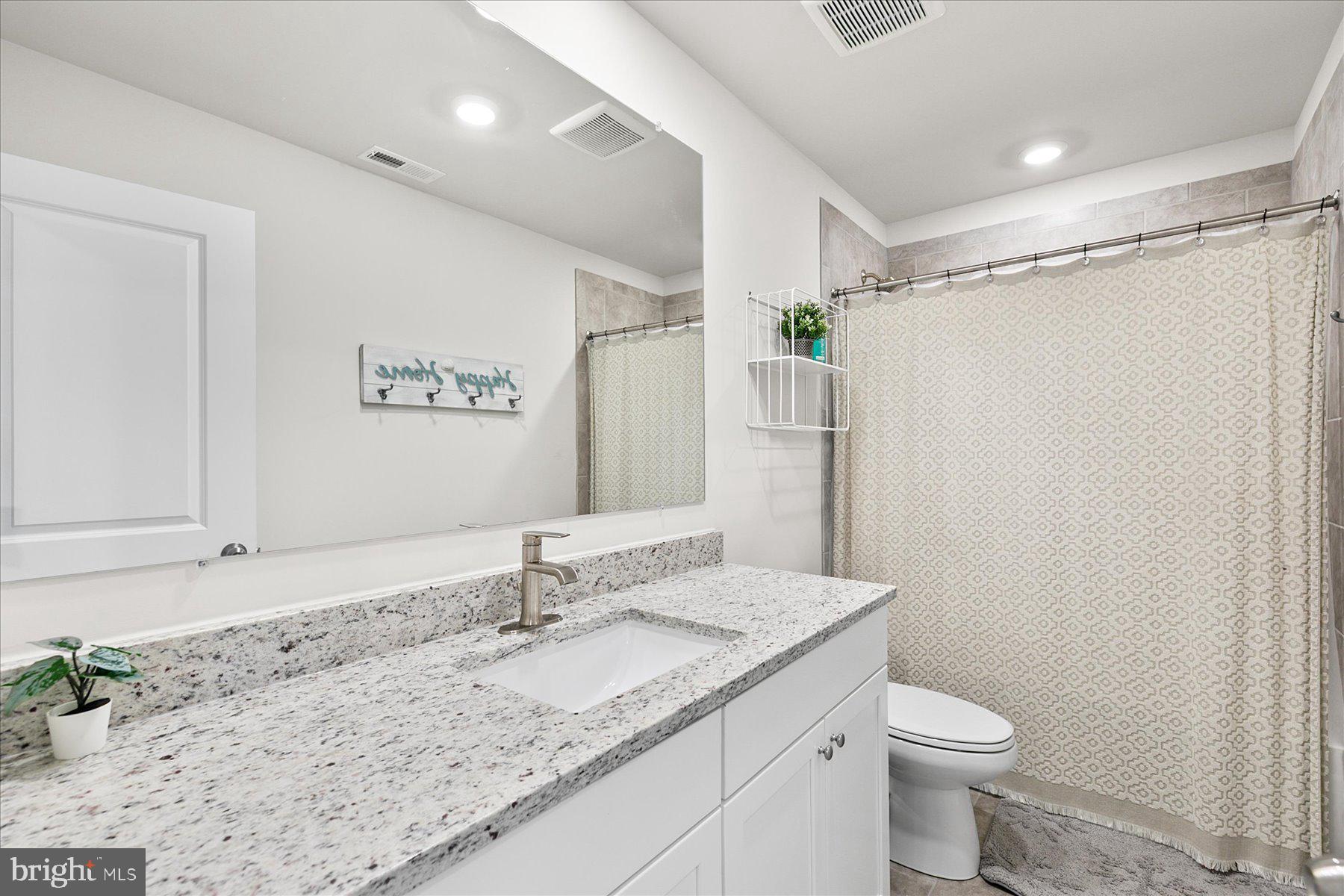 9503 Seascape Lane, Unit 4 Berlin, MD 21811 - Photo 33 of 52 a bathroom with a granite countertop sink toilet and shower