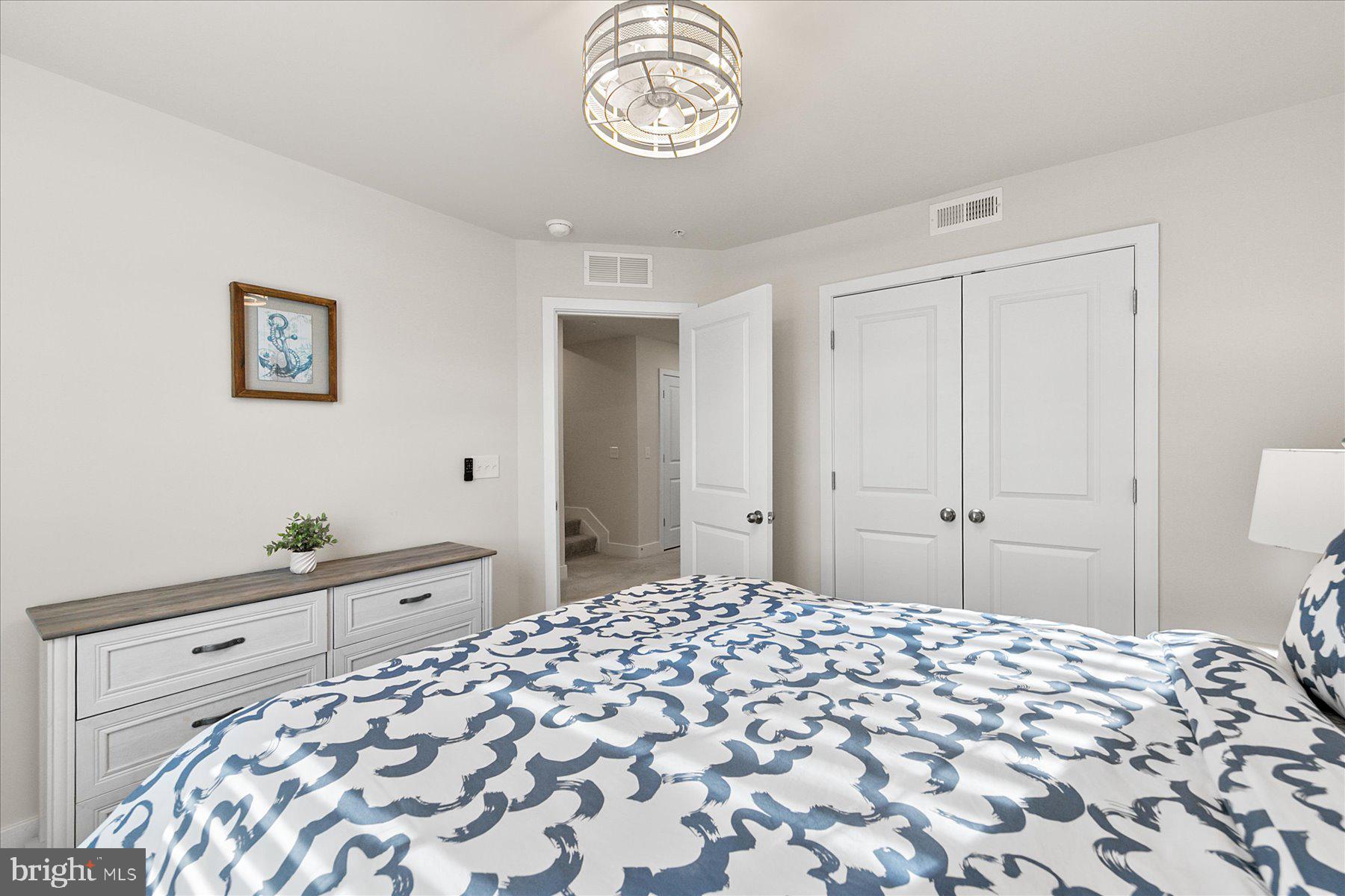 9503 Seascape Lane, Unit 4 Berlin, MD 21811 - Photo 35 of 52 a bedroom with a bed and a chandelier